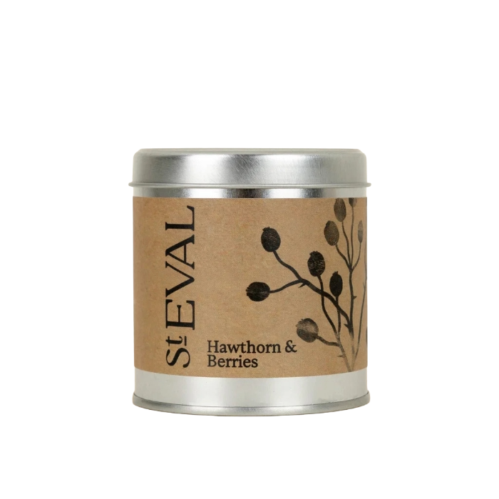 A St Eval Hawthorn & Berries candle in a round silver metal tin with a brown kraft paper label featuring black berry illustrations.