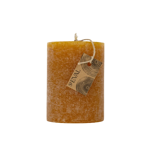 A textured, cylindrical amber-colored wax candle with a rustic, crumbled surface, featuring a small paper hangtag with the brand name 'SEXAL' and a twine loop at the top, isolated on a white background.