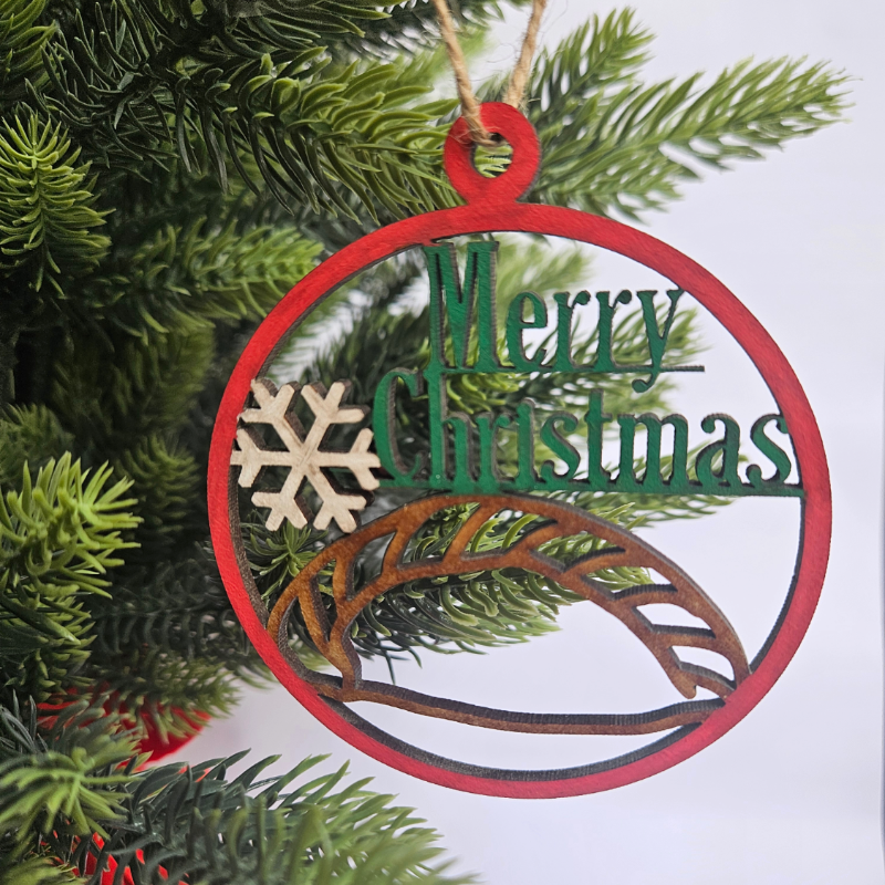 Decorative Christmas ornament with 'Merry Christmas' text and snowflake design on a tree.