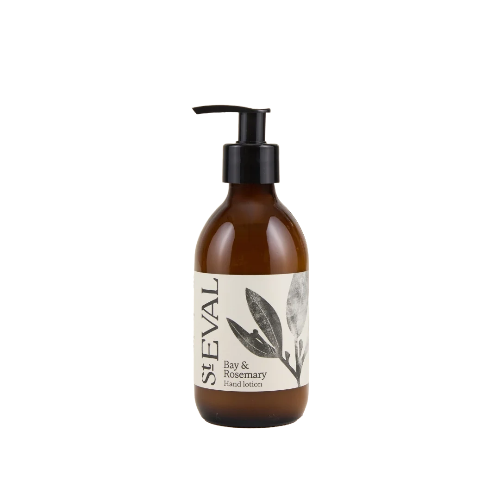 An amber glass pump bottle of Seval Bay & Rosemary Hand Lotion with a black dispenser and a cream-colored label featuring botanical illustrations.