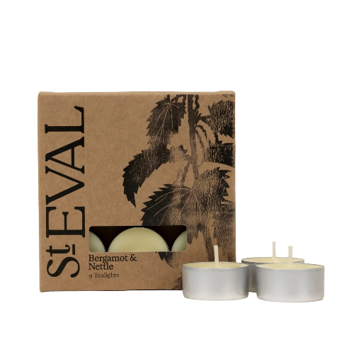 StEVAL Bergamot & Nettle 9 tea lights, showing the brown kraft paper packaging box with black botanical illustrations and three silver metal tea light tins with cream-colored wax on a white background.