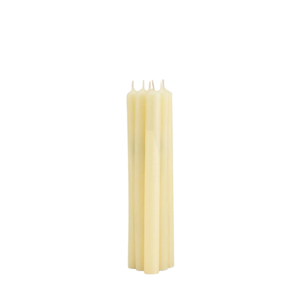 Four unbleached wax taper candles standing upright in a tight cluster against a plain white background.