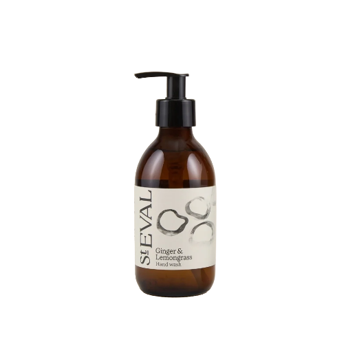 An amber glass pump bottle of SEVAL Ginger & Lemongrass hand wash, featuring a black pump and a cream-colored label with minimalist black and gray illustrations, set against a plain white background.