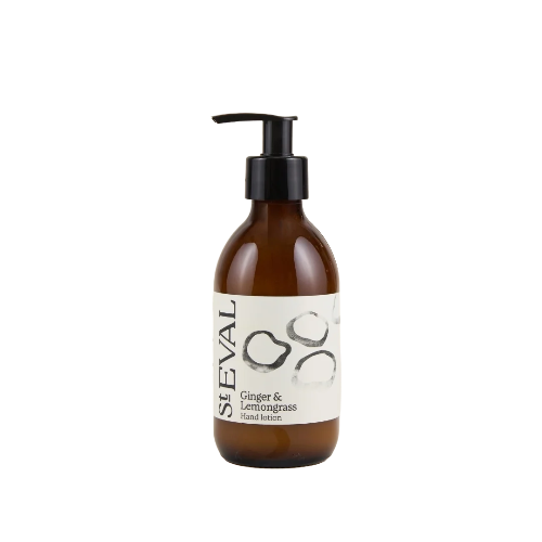 Seval Ginger & Lemongrass hand lotion in an amber glass pump bottle with a black dispenser and a white label featuring black text and minimalist illustrations.