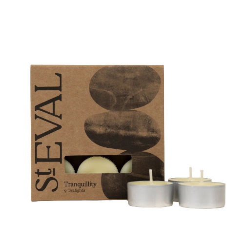 StEVAL Tranquility 9-tealight set, featuring a brown kraft paper box with a window showing the tealights inside, alongside three silver metal tealight cups on a white background.