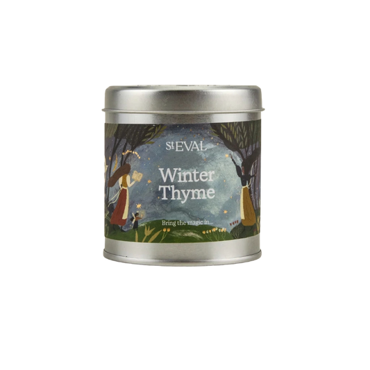 A silver metal tin candle with a colorful label reading 'S.EVAL Winter Thyme' and an illustration of a winter forest scene, centered on a plain white background.